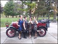 A group of people posing for a photo next to a red car

Description automatically generated with medium confidence