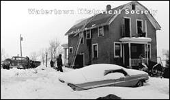 A snow covered house with a boat and a boat

Description automatically generated with medium confidence