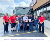 A group of people standing next to a vehicle

Description automatically generated with low confidence